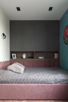 a bed sitting in the middle of a bedroom next to a wall with pictures on it