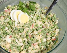 a glass bowl filled with peas and an egg