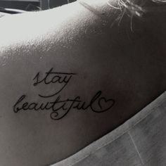 a woman's back shoulder with the words stay beautiful written on her left arm