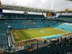 a stadium filled with lots of people sitting on the bleachers watching a football game