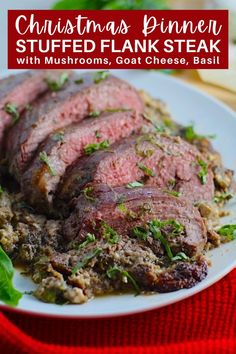 christmas dinner stuffed flank steak with mushrooms, goat cheese and basil on a white plate