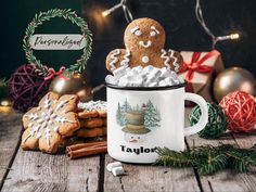 a mug filled with cookies and marshmallows on top of a wooden table