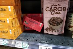 several bags of food are stacked on the shelf in a grocery store, and one bag is filled with coffee beans