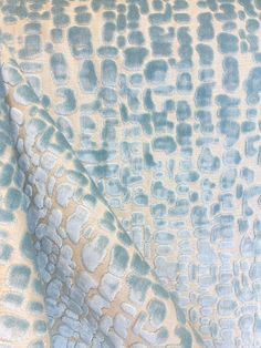 an abstract blue and white fabric with small squares on it's surface, as well as the background