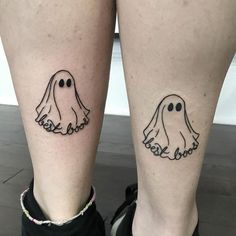 two people with matching tattoos on their legs, one has ghost faces and the other has words boo boo