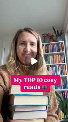 a woman holding a stack of books with the words my top 10 cosy reads