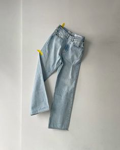 a pair of blue jeans laying on top of a white wall