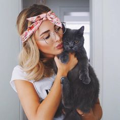 a woman holding a black cat in her arms and kissing it's face with the caption