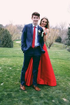 a man and woman in formal wear posing for the camera