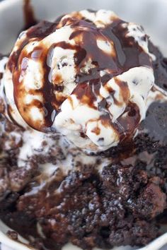 an ice cream sundae with chocolate and marshmallows in a white bowl