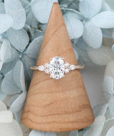 a diamond ring sitting on top of a wooden cone