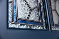 two stained glass windows sitting on top of a blue wall