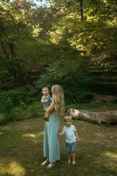 a woman and two children standing in the grass