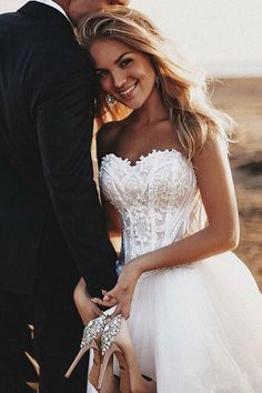 a man and woman standing next to each other in front of a desert landscape holding hands