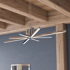 a modern chandelier hanging from a wooden ceiling in a room with blue walls