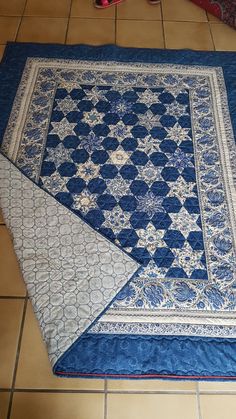 a blue and white quilt on the floor