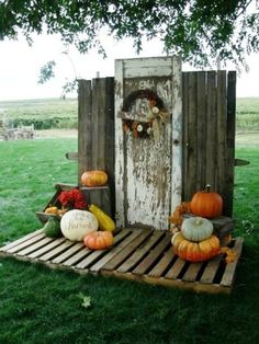 an outhouse with pumpkins and gourds on it