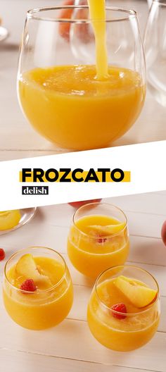 two glasses filled with orange juice on top of a white table next to apples and strawberries