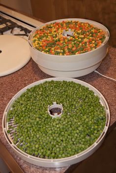 two bowls filled with peas sitting on top of a counter