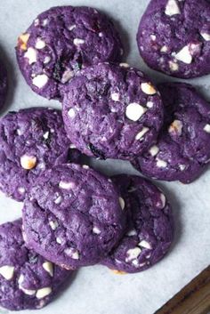 purple cookies with white sprinkles are on a baking sheet and ready to be eaten