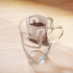 a glass cup filled with liquid sitting on top of a table