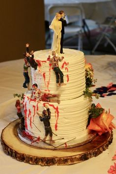 a wedding cake decorated with zombies and bride and groom figurines sitting on top of it