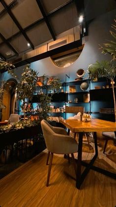 a room filled with lots of furniture and plants on top of wooden tables in front of shelves