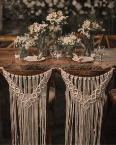 the table is set with two vases and some flowers on top of each other