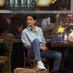 two people sitting at a table in front of a sign with the words perk on it