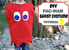 a child wearing a red ghost costume standing in front of a tree with the words, diy pac - man ghost costume