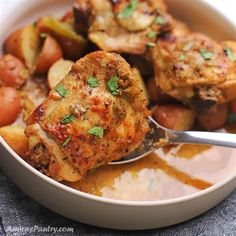 a white bowl filled with meat and potatoes