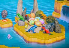 an animated scene with dinosaurs, eggs and rocks in the water on a floating island