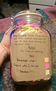 a hand holding a jar filled with colorful sticky notes and writing on the inside of it