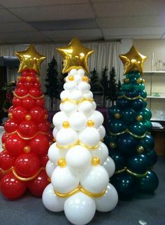 three christmas trees made out of balloons in an office