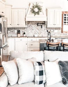 a living room filled with furniture next to a kitchen