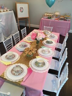 the table is set with pink and white china