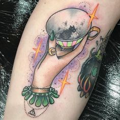 a person with a tattoo on their arm holding up a cup and saucer in the air