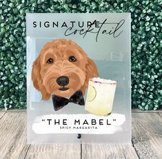 a sign with a dog wearing a bow tie next to a glass of lemonade