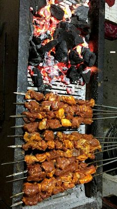 several skewers of food cooking on an outdoor grill