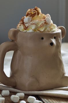 a mug filled with marshmallows on top of a table