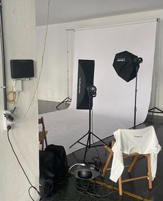 an empty photo studio with chairs and lighting equipment