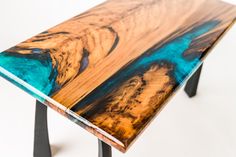 a wooden table with blue and brown designs on it's top, sitting against a white background