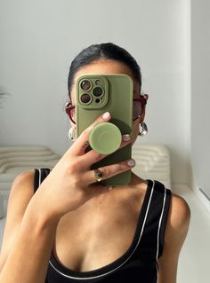 a woman taking a selfie with her phone in front of her face and wearing glasses