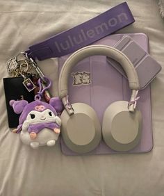 headphones, keychain, and other items are laying on a white sheet