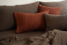 two brown and orange pillows on a bed