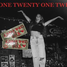 a woman standing on top of a skateboard in front of a sign that says one twenty one two