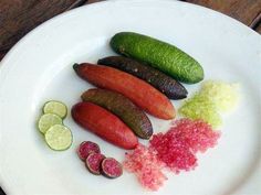 several different types of food on a white plate with limes and pickle slices