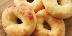 four bagels sitting on top of a wooden cutting board