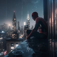 a man sitting on top of a roof in the rain looking out over a city at night