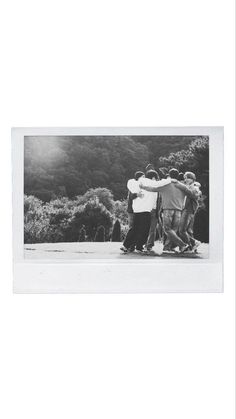 black and white photograph of four people hugging each other